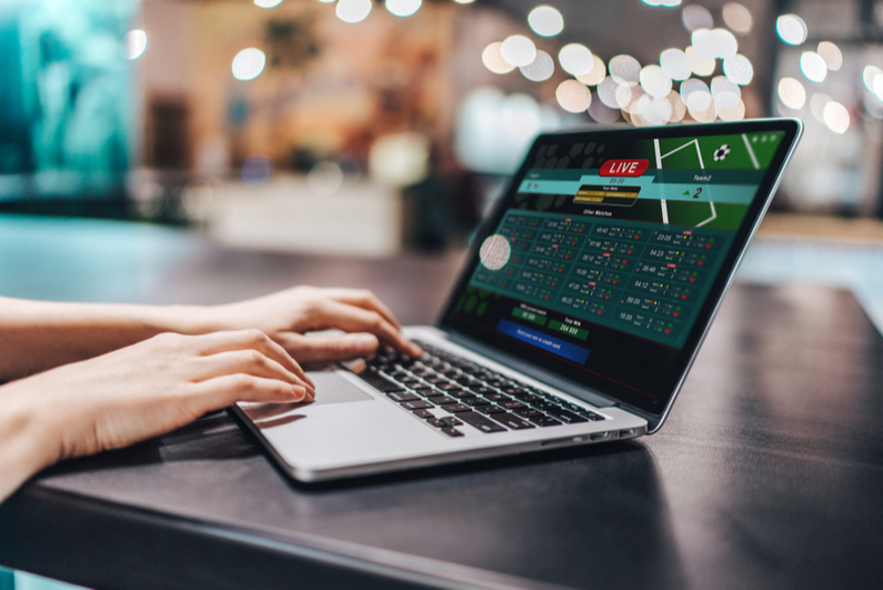 Hands of a woman placing online bets on a laptop