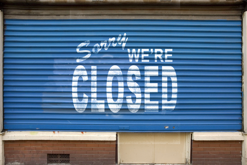 store shutters with 'sorry we are closed' printed