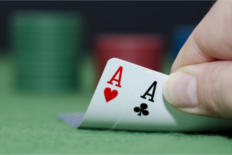 Poker player with pocket aces as hole cards