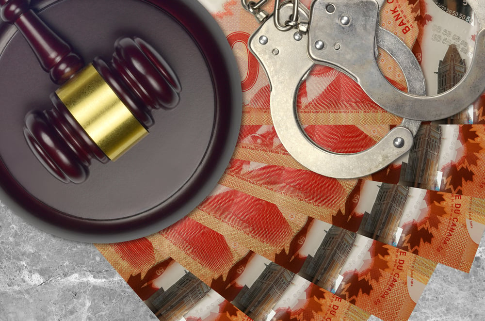 judge's gavel, handcuffs, and Canadian 50-dollar notes