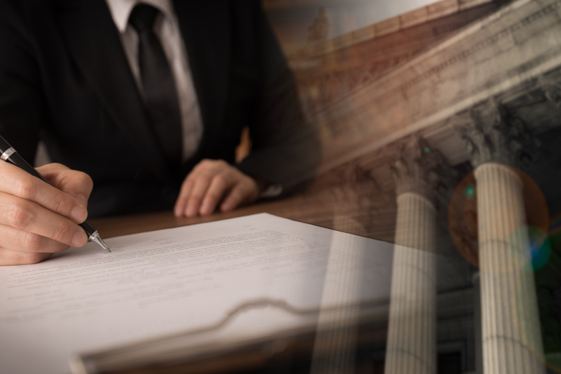 Man signing a bill with a government building in the background