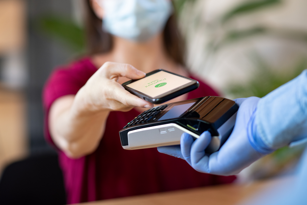 A woman using her phone for a contactless payment