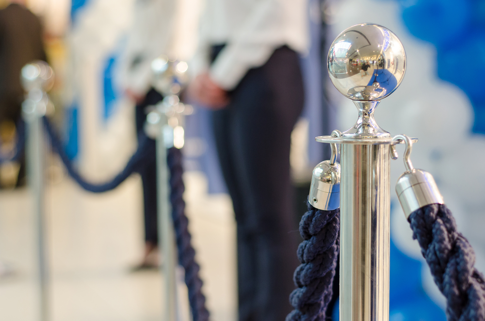 staff stand behind rope barriers at a venue