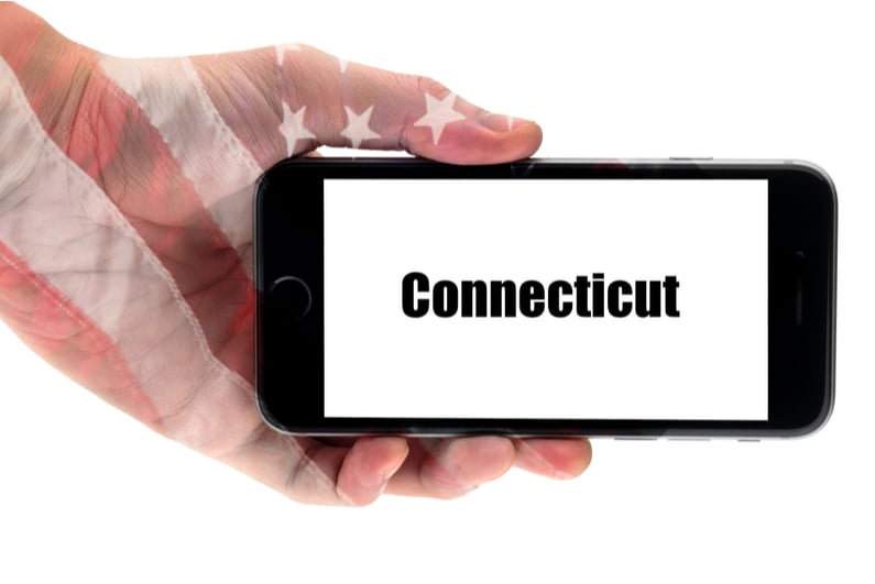 hand holding smartphone with the word Connecticut on screen